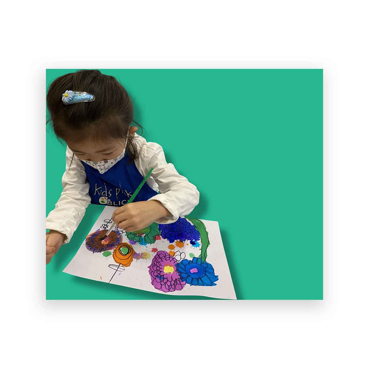 Child proudly working on flowers painting, a result of our private art lessons